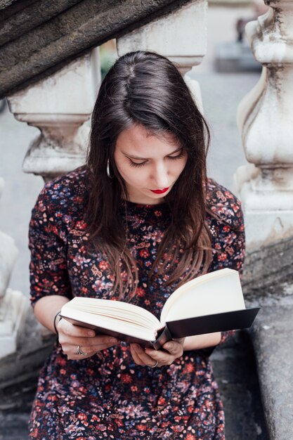 Girl reading a book in the street