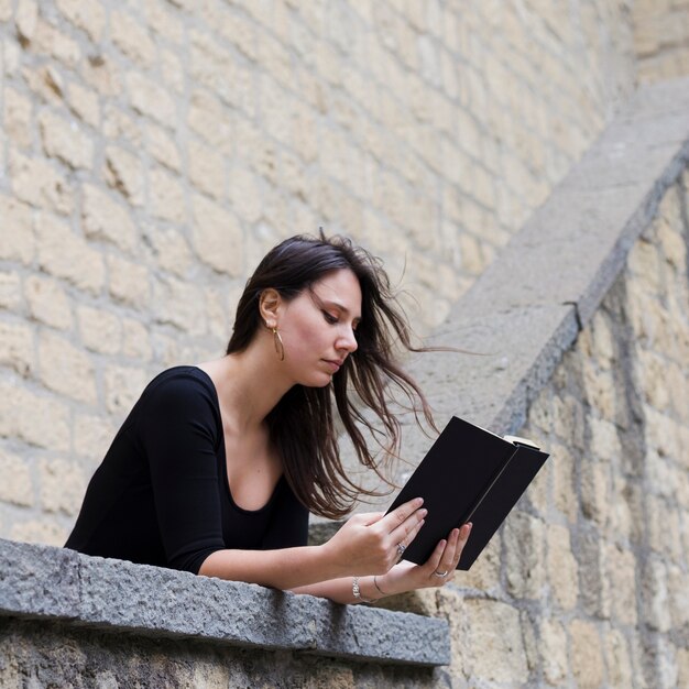 Girl reading a book in the street