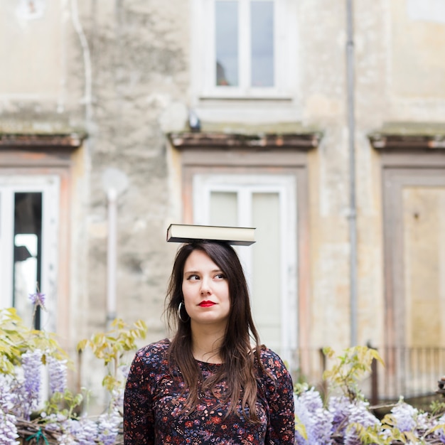 Foto gratuita ragazza che legge un libro in strada