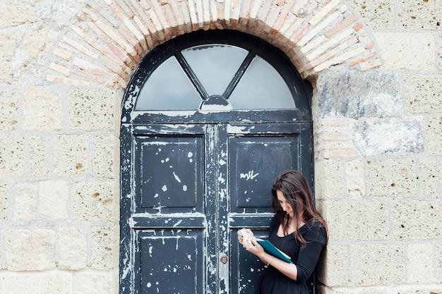 Ragazza che legge un libro in strada