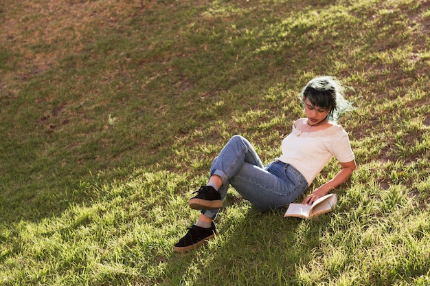 Girl reading on a sunny hill