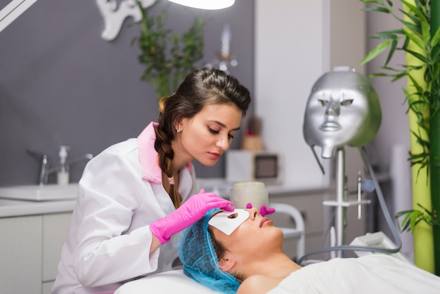 Free photo girl receiving facial treatment in a beauty salon