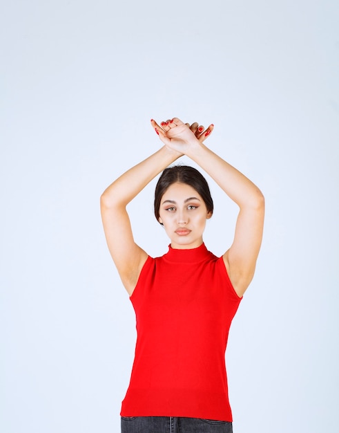 Ragazza in camicia rossa che dà pose neutre, positive e accattivanti.