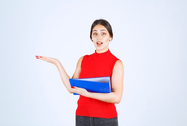 Free photo girl in red shirt holding a blue business folder.