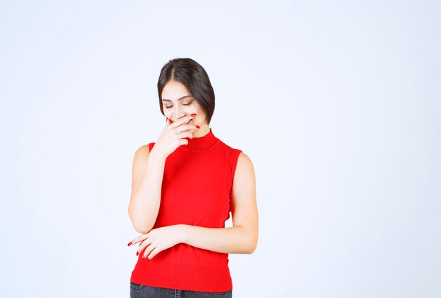 Girl in red shirt holding her breath because of bad smell.