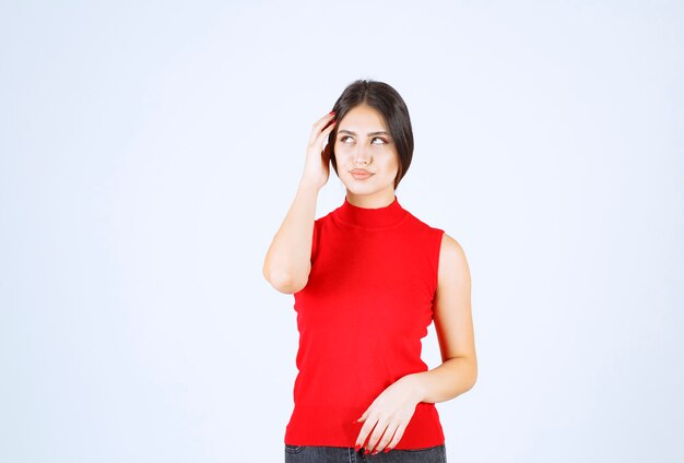 Girl in red shirt looks sad and disappointed.