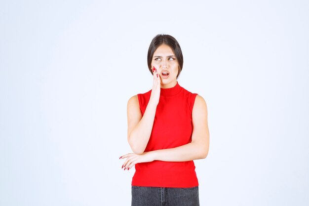 Free photo girl in a red shirt looks scared and terrified.