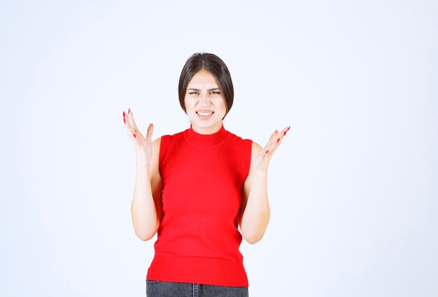 Girl in red shirt looks stressed and nervous.