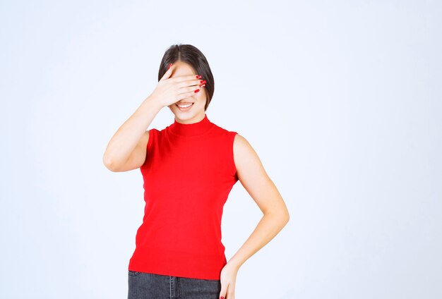 Girl in red shirt looks surprized by something unexpected.