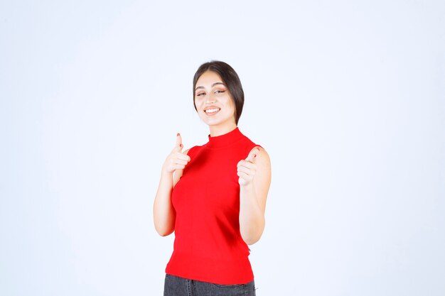 Girl in red shirt noticing someone ahead and greeting him.