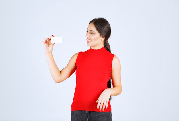 Girl in red shirt presenting her business card.