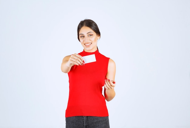 Девушка в красной рубашке, представляя ее визитную карточку.
