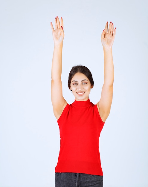 손을 올리고 위에 가리키는 빨간색 셔츠에 소녀.