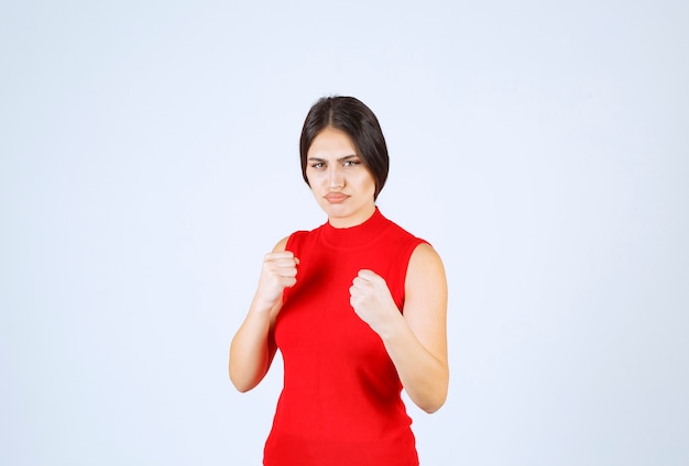 Girl in red shirt showing her fists and power.
