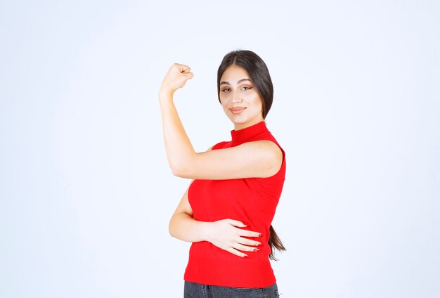 Girl in red shirt showing her fists and power.