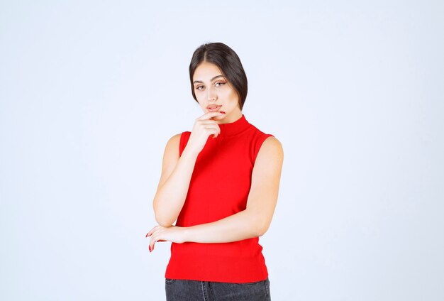 Girl in red shirt thinking and analizing.