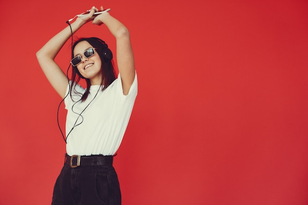 Free photo girl on a red wall with headphones