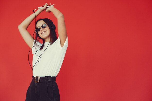 Girl on a red wall with headphones