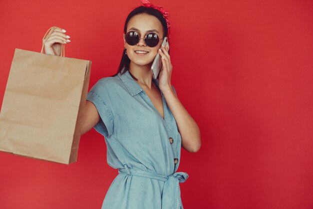 girl on a red wall with shopping bags
