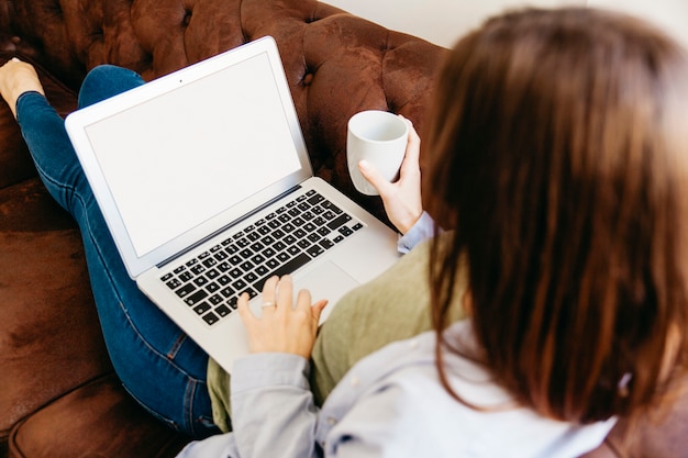Girl relaxing with drink and laptop