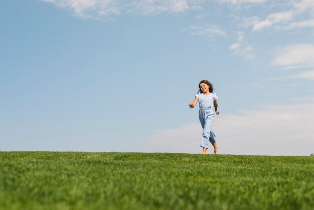 草の上を裸足で走っている少女