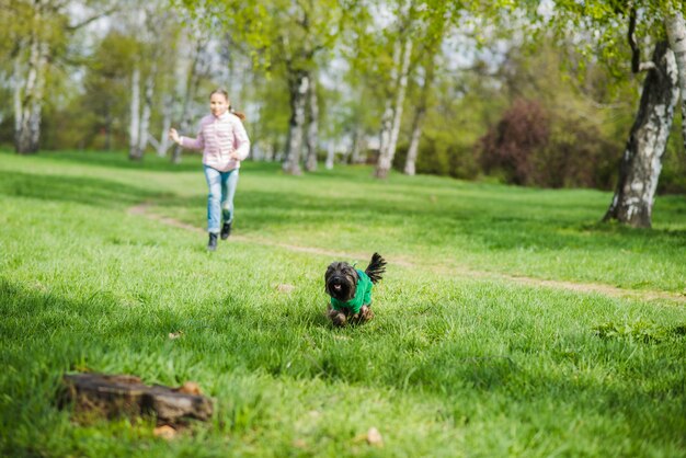 Girl running behind her dog