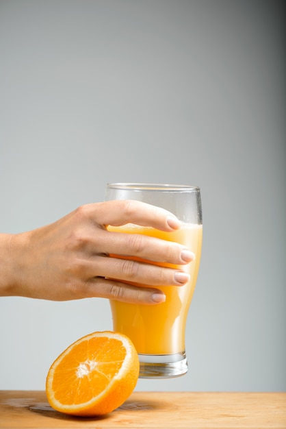 Девушка рука держит стакан апельсинового сока