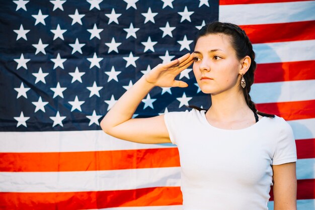 미국 국기 앞에서 경례하는 여자