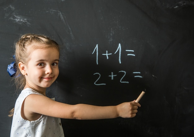 girl schoolgirl near blackboard