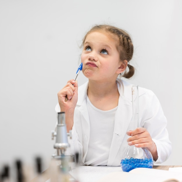 Foto gratuita ragazza nella classe di scienze che fa ricerca