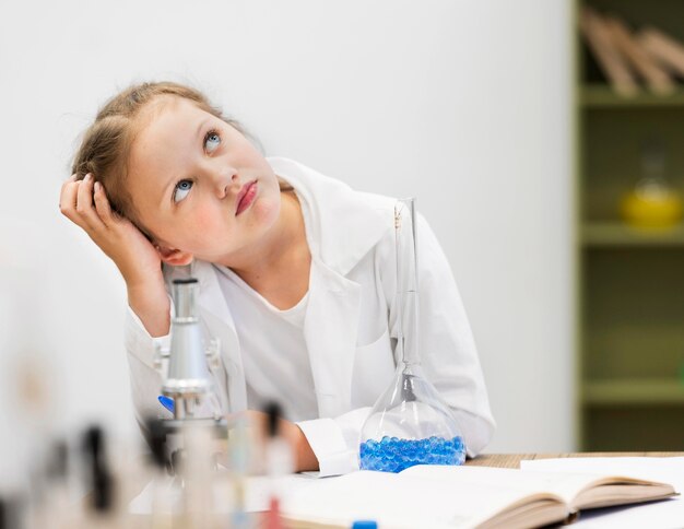 Girl in science class thinking