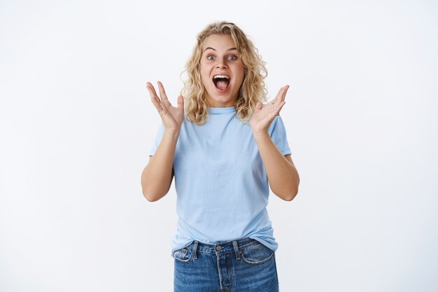 Girl screaming from happiness and excitement as seeing favorite pop singer reacting thrilled and overwhelmed raising hands from surprise and positive emotions yelling in joy and amazement