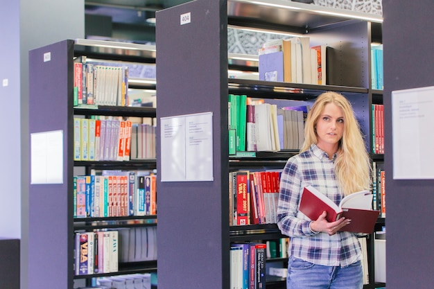 Foto gratuita ragazza ricerca libro in biblioteca