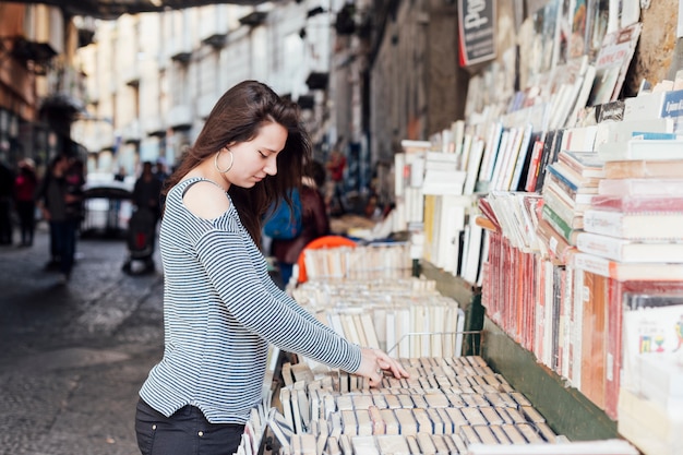 Free photo girl searching books in the bookstore