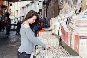 Foto gratuita ragazza alla ricerca di libri in libreria