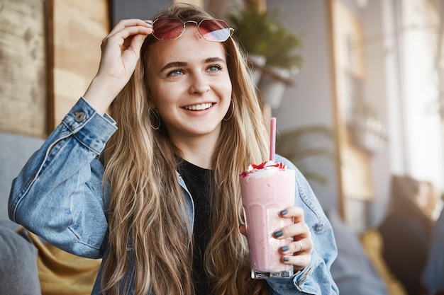 Girl seeing familiar face on street while sitting in local cafe
