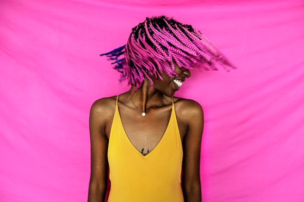 Бесплатное фото Девушка трясет розовыми заплетенными волосами