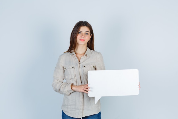 girl in shirt holding speech bubble and looking cheerful 