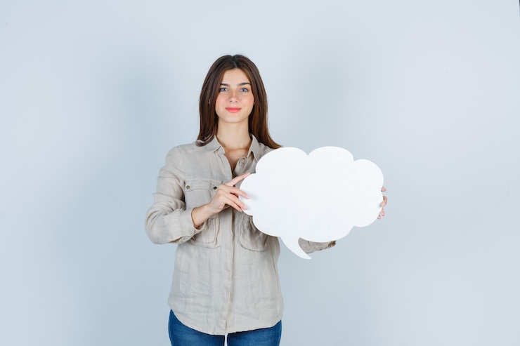 Free Photo girl in shirt holding speech bubble and looking positive 