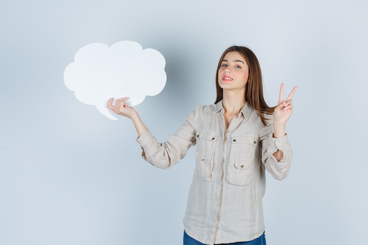 Free Photo girl in shirt holding speech bubble, showing peace gesture and looking cheerful 