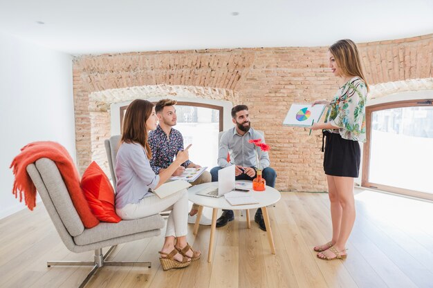 Girl showing diagrams to coworkers