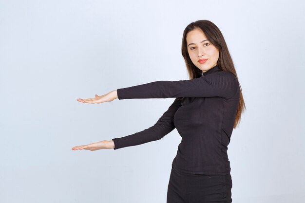 Girl showing the estimated height of an object. 