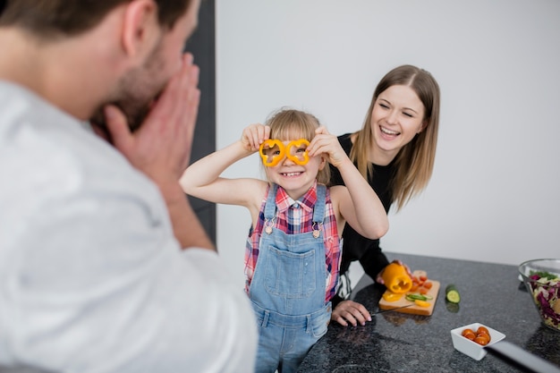 Girl showing pepper glasses to parents