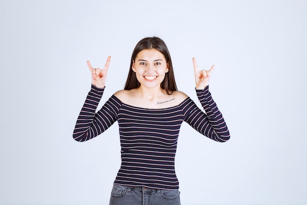 Free photo girl showing rabbit or wolf ear sign.