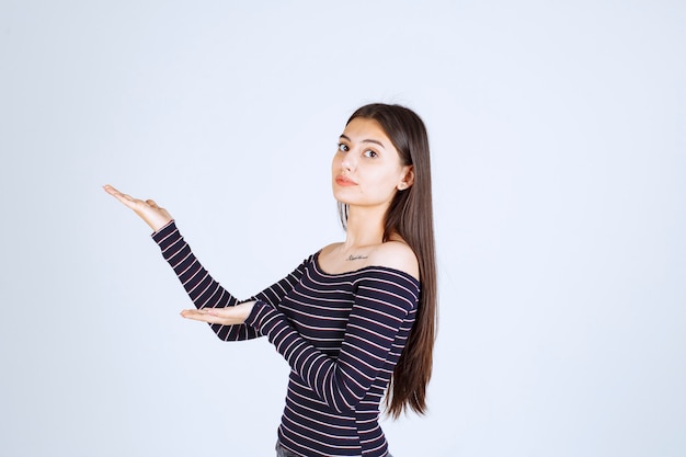 Free photo girl showing something in her open hand.