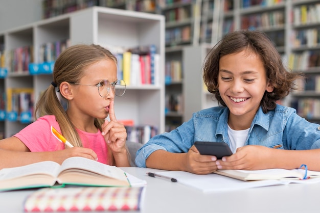 Ragazza che zittisce un ragazzo in biblioteca