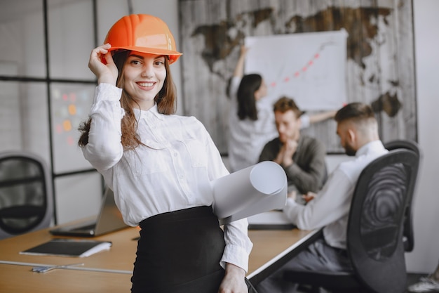 Girl signs the documents.  Lady in a red helmet. Managerl working in the office.