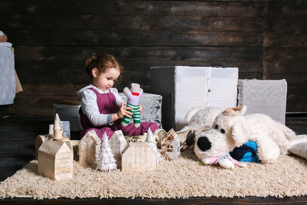 Girl sitting on carpet playing with puppet