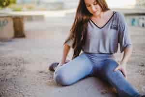 Free photo girl sitting on concrete floor stretching