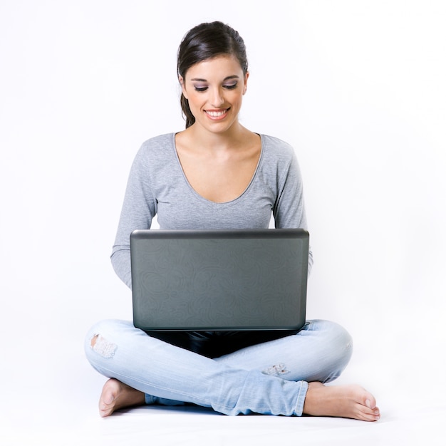 Free photo girl sitting crossed legs with gray laptop